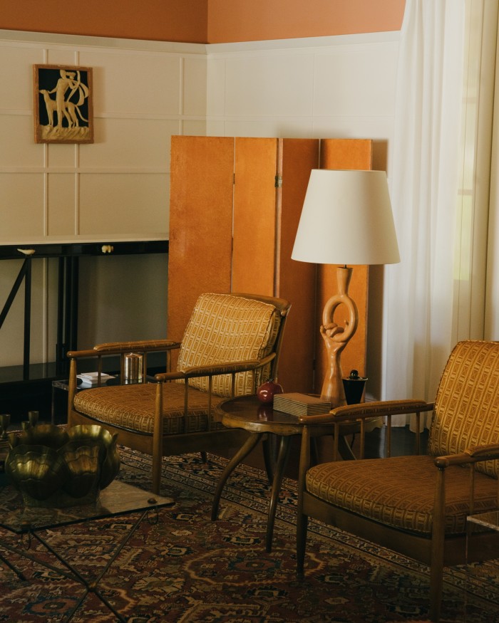 Midcentury Scandinavian chairs, a 1960s Jacques Adnet coffee table and a 19th-century Persian rug in the living room