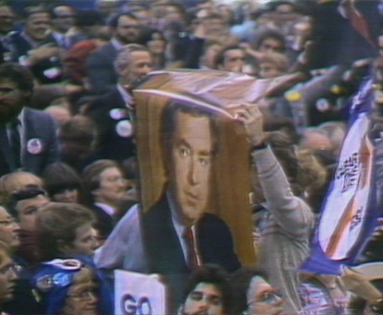 A large poster of a man's head in a crowd