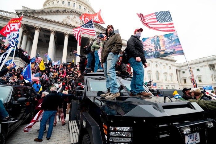 Trump supporters stand on the U.S. Capitol Police armored vehicle as others take over the steps of the Capitol on January 6 2021