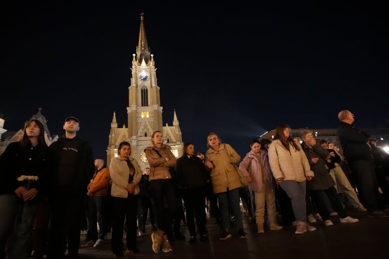 People light candles for the victims after an outdoor roof collapse at a train station.