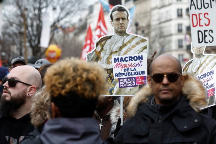 Protesters hold signs up during a demonstration against pension reform plans in Paris, France, in March 2023