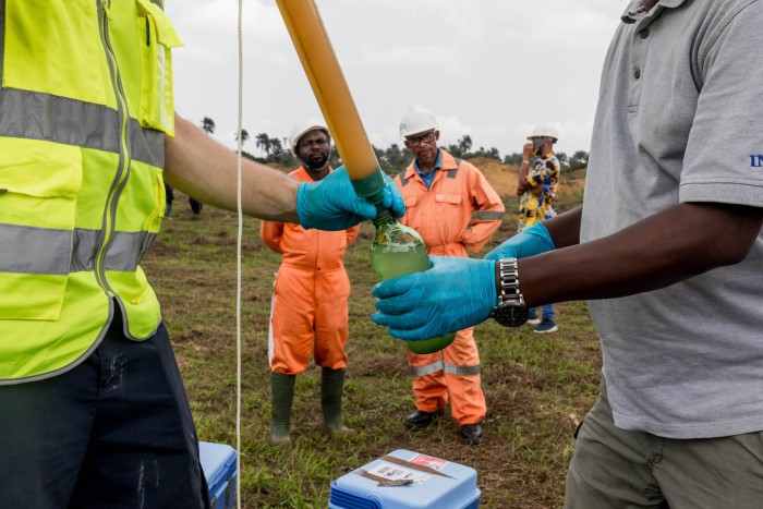 Workers take water samples in Ogale to test contamination levels