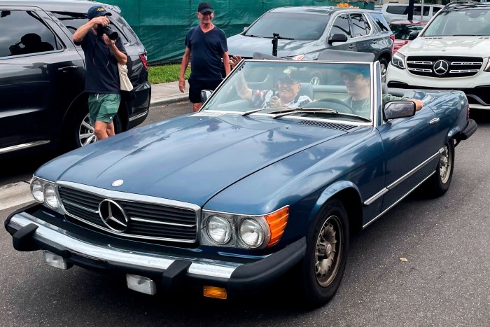 Rudy Giuliani is pictured in the passenger seat of a Mercedes convertible 