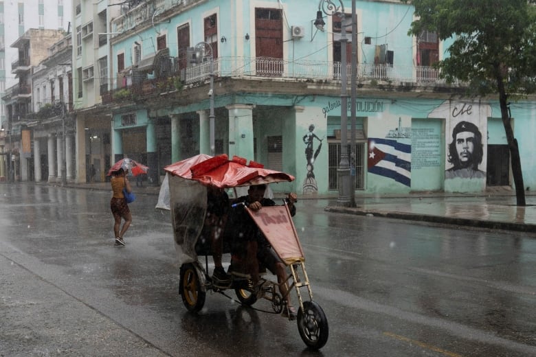 People are seen on the street as Hurricane Rafael passes by Havana, Cuba.