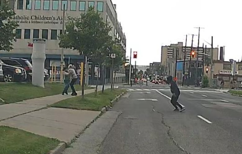 A screenshot from dashcam footage released by Hamilton police shows a shooting in broad daylight in August, with one person using another as a human shield.