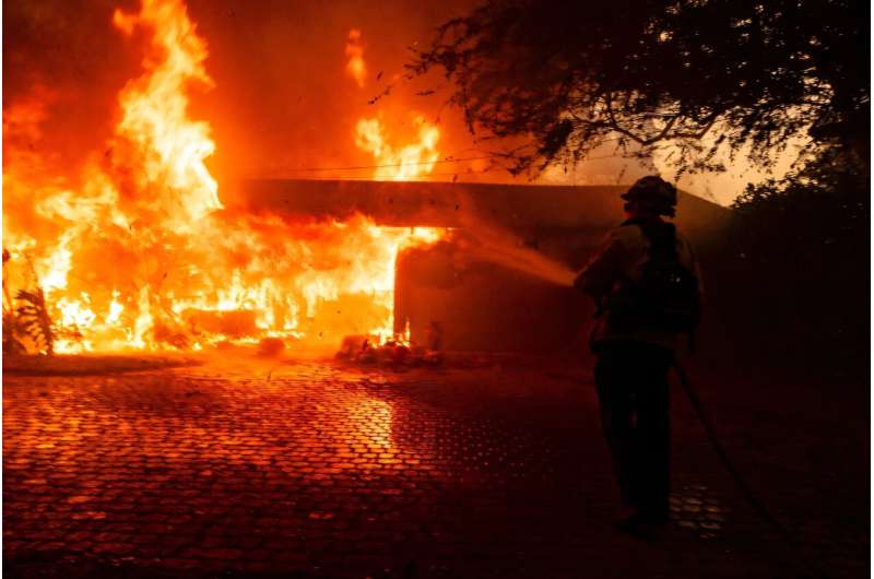 A firefighter attempts to control the blaze burning a house in Camarillo, California on November 6, 2024