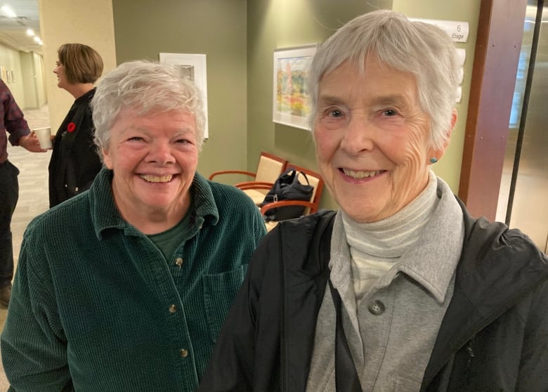 Two white-haired women smiling broadly.