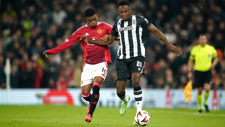 PAOK's Baba Rahman, right, and Manchester United's Amad Diallo challenge for the ball during the Europa League opening phase soccer match between Manchester United and PAOK at the Old Trafford stadium in Manchester, England, Thursday, Nov. 7, 2024. (AP Photo/Dave Thompson)