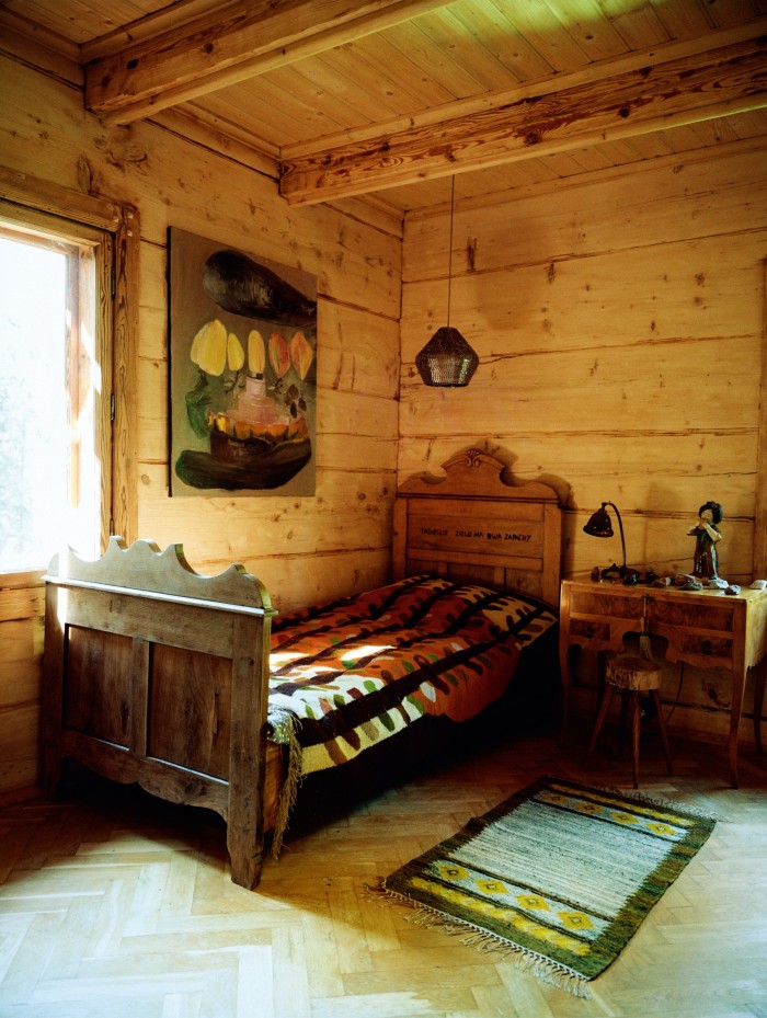 A guest room with a 1970s Zakopane School of Art rug and Cepelia bed cover and, on the wall, Torcik, 2015, by Polish artist Luka Woźniczko