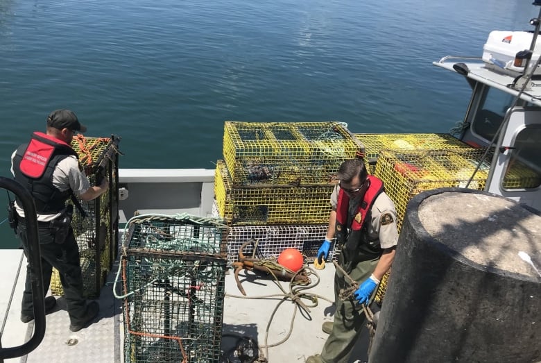 Two man unloading lobester traps from the ocean. 