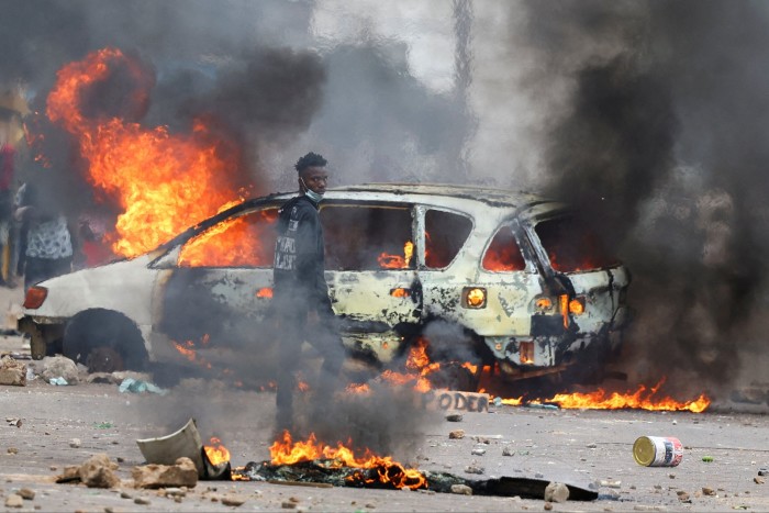 A protester looks on near a burning barricade during a ‘national shutdown’ against the election outcome, in Maputo, Mozambique