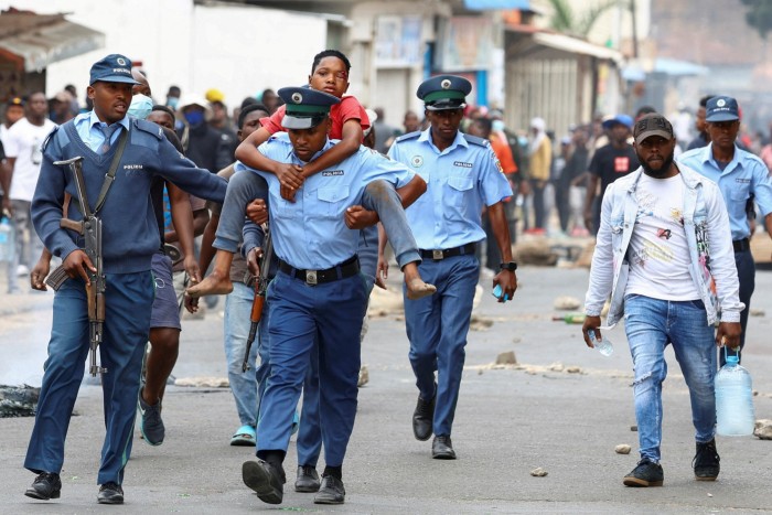 A police officer carries an injured person during a ‘national shutdown’ against the election outcome, at Luis Cabral township in Maputo, Mozambique