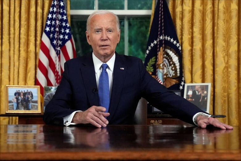 A man with white hair and a navy suit addresses Americans from the Oval Office in the White House.