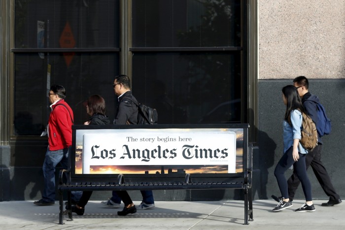 People walk past the offices of the Los Angeles Times newspaper