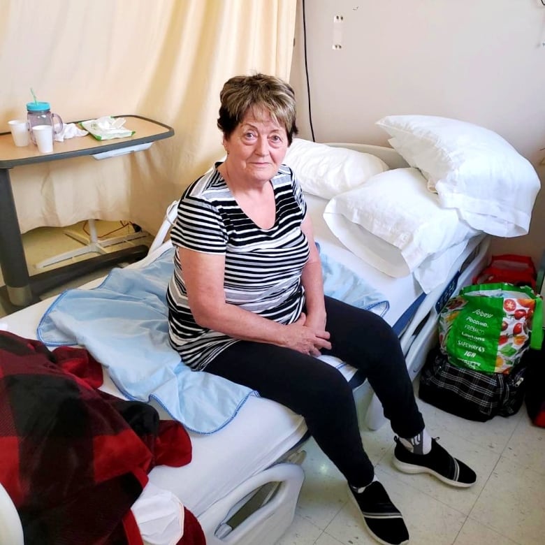 Elderly woman sitting on edge of hospital bed