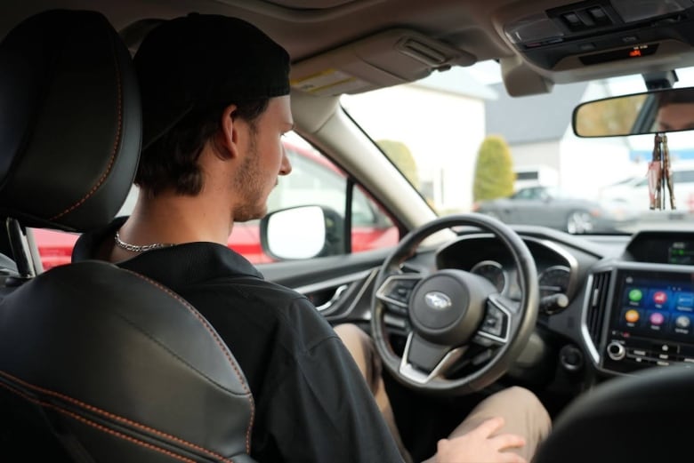 a white man is seen in the driver's seat of a subaru 