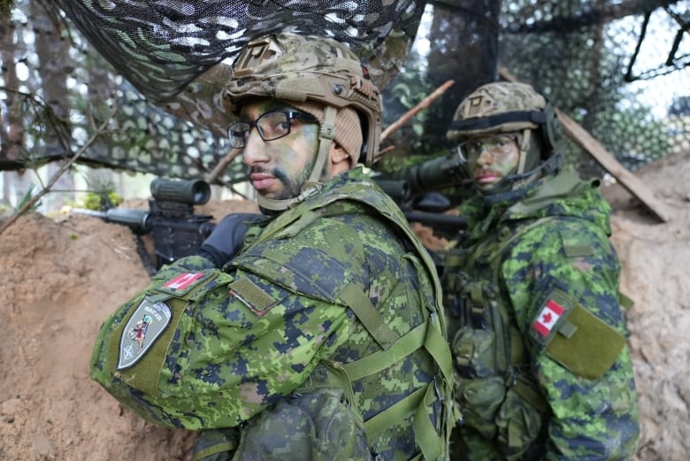 Corp Youssef Zitouni and Corp. Oliver Hutpays demonstrate how they would observe enemy movements from a trench during the exercises.