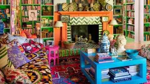 Johnson Hartig’s living room is a riot of colour and pattern, including an orange mantelpiece with green and white zigzag tiling and a bright blue coffee table