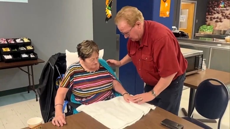 Elderly woman helping elderly woman in wheelchair