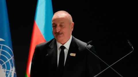 Ilham Aliyev stands at a podium during the COP29 UN climate summit