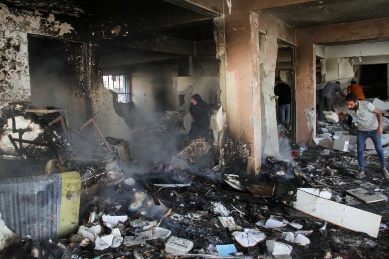 Palestinians inspecting rubble in Gaza City. 