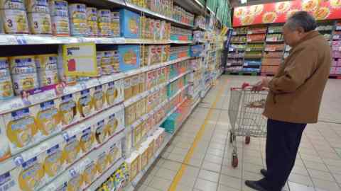 An elderly man shops for milk formula in a supermarket in China