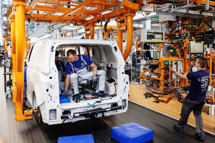 A man works inside a van on a production line