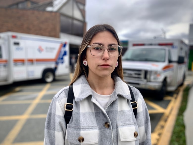 A woman outside a hospital with serious expression