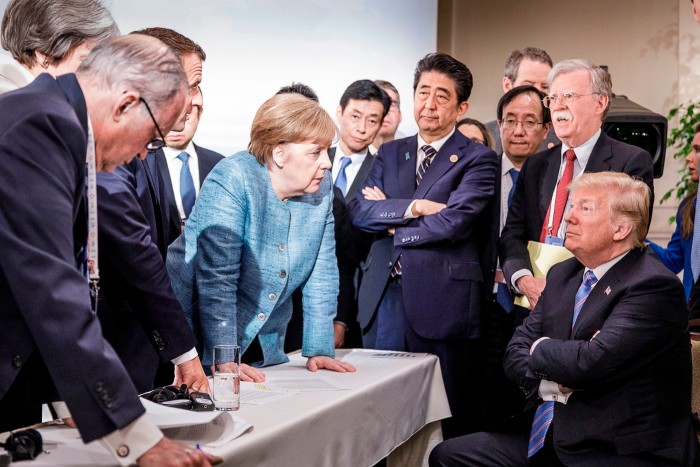 German Chancellor Angela Merkel deliberates with US president Donald Trump on the sidelines of the official agenda on the second day of the G7 summit on June 9, 2018