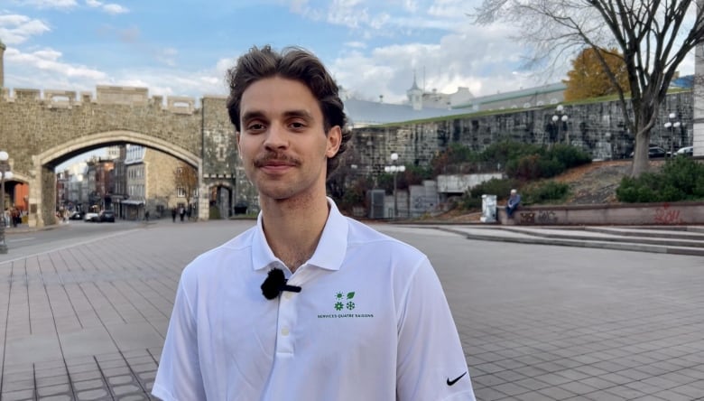 A man looks at the camera, standing in front of Old Quebec City.