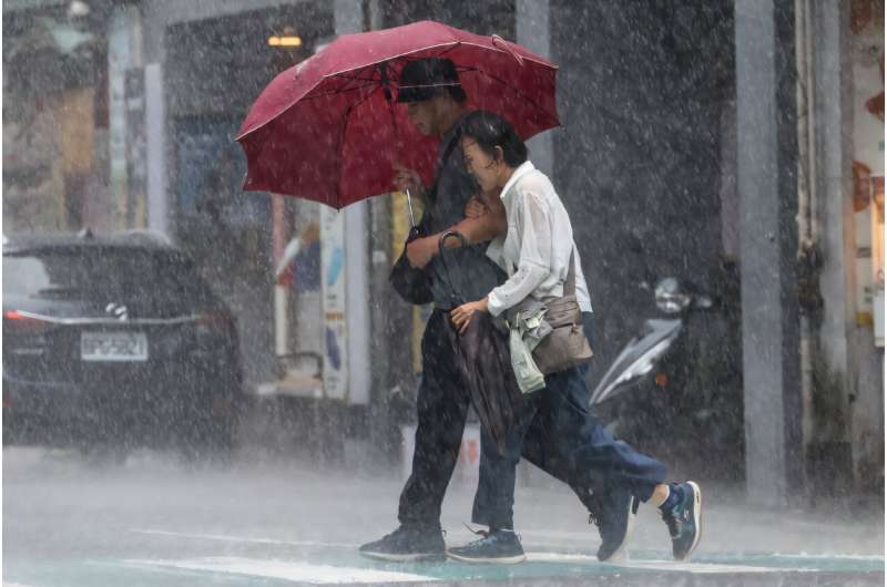 People walk along a street in heavy rain due to Super Typhoon Kong-rey in Keelung, Taiwan, on October 31