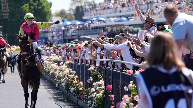 Jockey Robbie Dolan celebrates with fans at Flemington