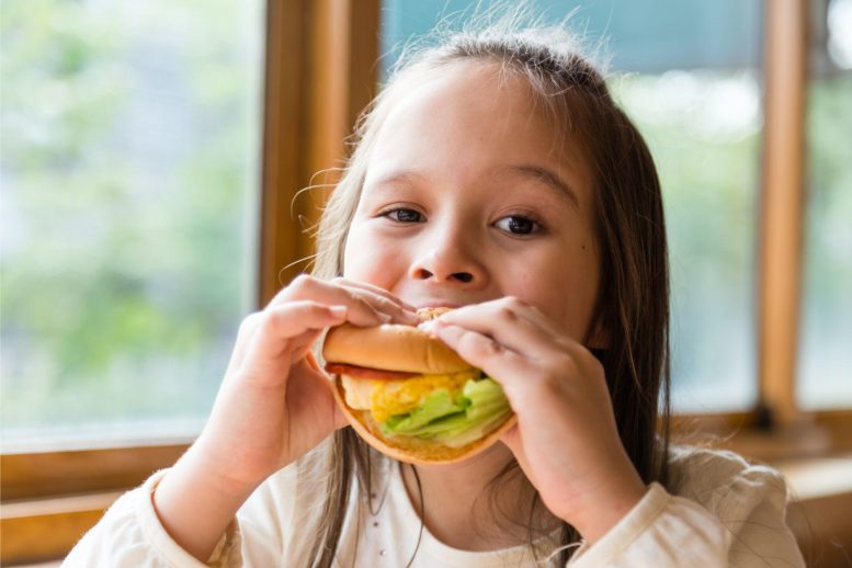 Young Girl Eating Hamburger