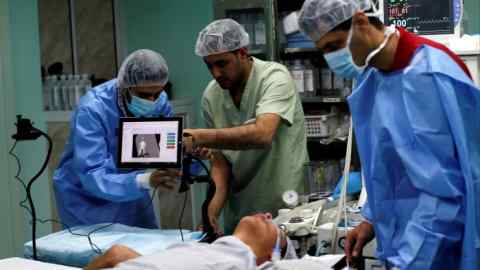 A patient awaits a Proximie surgery, with a doctor in Beirut guiding a Palestinian surgeon,  at Al Awda Hospital in the northern Gaza Strip