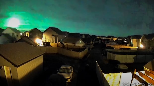 A large orb glows in one corner of the sky creating a green tint alongside it.