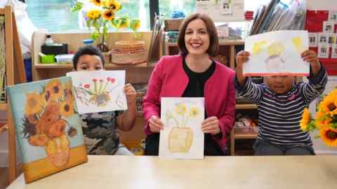 Education Secretary Bridget Phillipson holding her painting of sunflowers, alongside pupils Wyatt, aged 4 (left), and Aicha, aged 4, during a visit to the school-based nursery at Ark Start Oval, East Croydon