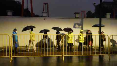 Police officers keep watch near barricades set up along Julu road where people in Halloween costumes gathered last year