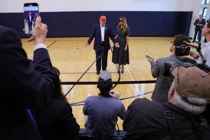 Donald Trump, accompanied by wife Melania, speaks to reporters after voting in Palm Beach on Tuesday