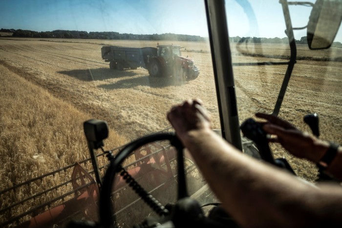 A farmer drives a tractor across Lincolnshire farmland